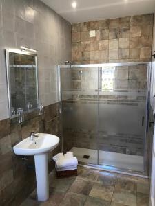W łazience znajduje się umywalka i prysznic. w obiekcie Hospedería Santa Cruz w mieście San Lorenzo de El Escorial