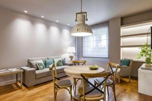 a living room with a couch and a table and chairs at Ferrini Home - Etnea Collection in Catania