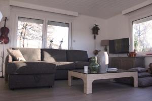 uma sala de estar com um sofá e uma mesa de centro em My Secret Garden em Diepenbeek