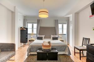 a bedroom with a large bed and a couch at Inn Bairro Alto BA Sweet in Lisbon