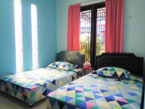 1 dormitorio con 2 camas individuales y ventana en Bukir Five, en Malang