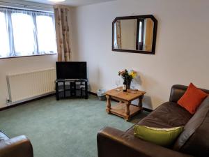 a living room with a couch and a television at Princes Lodge in Telford