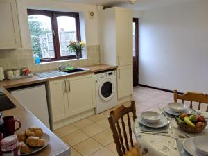 uma cozinha com uma mesa e uma máquina de lavar roupa em Princes Lodge em Telford