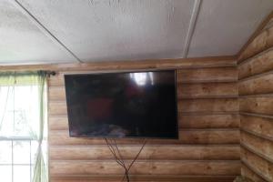 a flat screen tv on a wall in a room at MARGARITAVILLE ON THE SUWANNEE RIVER in Mayo