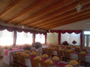 un salón de banquetes con mesas, sillas y ventanas en Pansion Komfor Moča en Makarska