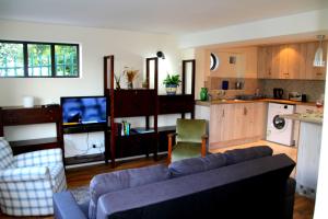 a living room with a couch and a kitchen at Fisherman's Watch Cottage in Cape Town