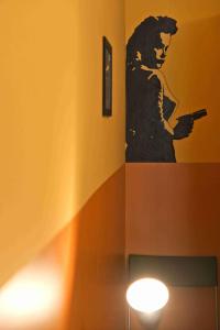 una pintura de una mujer sosteniendo un celular en una pared en Sunflower Hostel Berlin, en Berlín