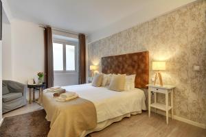 a bedroom with a large bed and a chair at Inn Bairro Alto BA Sweet in Lisbon