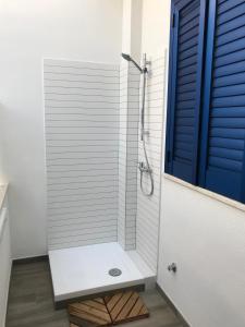 een badkamer met een douche met een blauwe deur bij A due passi dal mare in Porto Cesareo