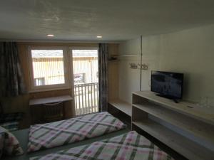 メラウにあるHaus Mittagspitzeのベッドルーム(ベッド1台、テレビ、窓付)