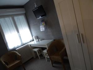 mały pokój ze stołem i telewizorem na ścianie w obiekcie Au Bon Accueil w mieście Alban