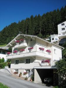 um edifício de apartamentos branco com flores nas varandas em Garni Montana em Kappl