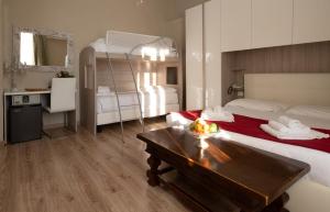 皮昂比诺Antico Hotel Moderno的一间卧室配有一张床、一张桌子和一张双层床。 更多37张照片