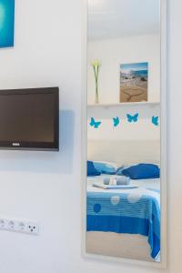 einen Spiegel in einem Zimmer mit einem Bett und einem TV in der Unterkunft Apartments Nona 1 in Hvar