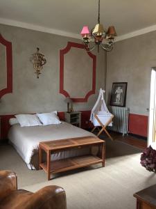 una camera da letto con un letto, un tavolo e uno specchio di La Jauberthie a Vanxains Altre 38 foto