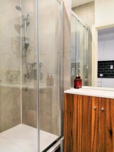 y baño con ducha acristalada y lavamanos. en Horse Fair Apartments in Birmingham City Centre by HF Group en Birmingham