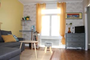 salon z kanapą, stołem i oknem w obiekcie Le Kooka w mieście Arras