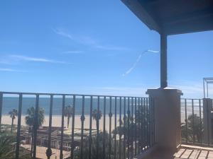 d'un balcon avec vue sur la plage et les palmiers. dans l'établissement Mirando al mar. Primera linea de playa, à Isla Canela