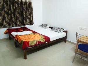 a bedroom with a bed in a room with a chair at Spice Cottage Homestay in Thekkady