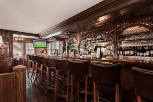 a bar with a row of bar stools at The Huntting Inn in East Hampton