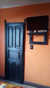 une porte avec une télévision à côté d'un mur dans l'établissement Hotel Recreo, à Mexico