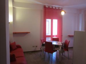 a dining room with a table and red curtains at Appartamenti Alba e Tramonto in Lampedusa