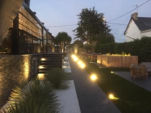 a garden with lights on the side of a building at Hotel-Restaurant Lann Roz / Côte Cuisine in Carnac