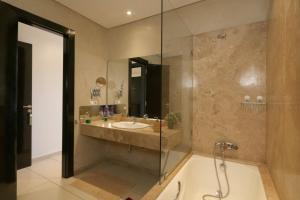 a bathroom with a tub and a sink and a shower at Sweet Jacob's Appartment Gueliz City Center in Marrakesh