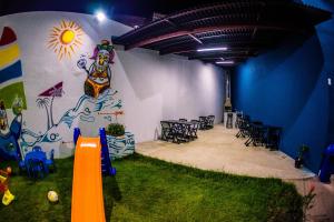 ein Zimmer mit einem Tisch und Stühlen sowie einem Wandbild in der Unterkunft Porto Flats in Porto De Galinhas