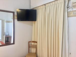 a room with a curtain and a television on the wall at Hotel Plaza San Juan in San Juan