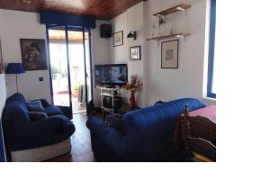 ein Wohnzimmer mit zwei blauen Sofas und einem TV in der Unterkunft La Bomboniera della Brigata Spendereccia! in Taormina