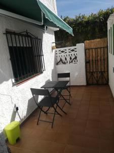 een patio met 2 stoelen, een tafel en een hek bij Apartamento La Muralla de Llanes in Llanes