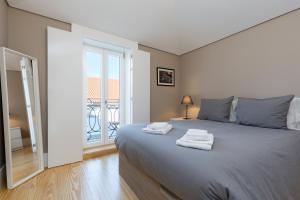 ポルトにあるPorto and Clérigos Views by Porto City Hostsのベッドルーム1室(大型ベッド1台、タオル付)