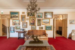 una sala de estar con sofá y una pared de pinturas. en Casa dos Arcos - Charm Guesthouse, en Albufeira