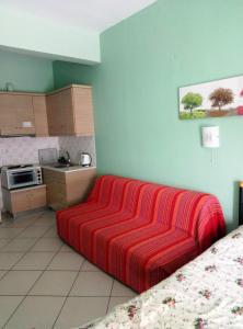 Habitación con cama y manta de rayas rojas en Xenon Christina, en Vivari