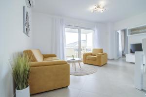 a living room with two chairs and a table at Apartments Luka - Villa Sunce in Senj