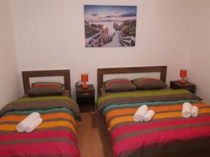 two beds in a room with slippers on them at Apartman Donji Kraj in Cetinje