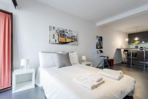 a bedroom with a white bed with towels on it at FLH Studio Alfama in Lisbon