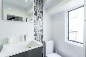 a white bathroom with a sink and a window at FLH Studio Alfama in Lisbon