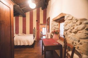 a bedroom with a bed and a table in a room at Mulìn Turcìn in Coassolo Torinese