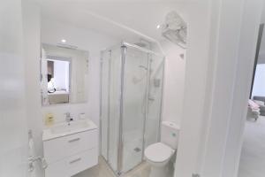 biała łazienka z prysznicem i toaletą w obiekcie APARTAMENTO RIALTO 2 w Maladze