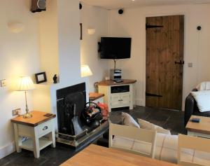 ein Wohnzimmer mit Sofa und Fernseher in der Unterkunft Dee Valley Cottages in Llangollen