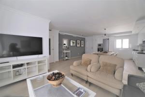 ein Wohnzimmer mit 2 Sofas und einem Flachbild-TV in der Unterkunft APARTAMENTO RIALTO 2 in Málaga