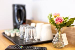 a remote control and a vase of flowers on a table at Wellesley Hotel in Ilford