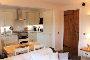 a kitchen and dining room with a table and a couch at Dee Valley Cottages in Llangollen
