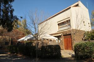 une maison en briques avec un arbre devant elle dans l'établissement Casa Rural "Casa de las Regatas", à Castuera