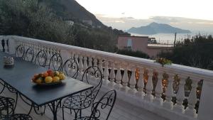 a bowl of fruit on a table on a balcony at Il Profumo di Capri in Massa Lubrense