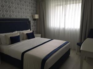 a bedroom with a large bed with blue and white pillows at HOTEL LES 3 VALLÉES in Saran
