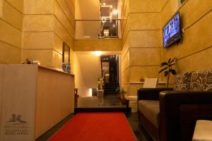 a living room with a red carpet and a tv at Al-Ahlam Hotel Apartments in Aqaba