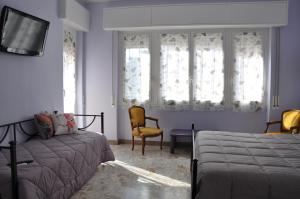 - une chambre avec un lit, une chaise et des fenêtres dans l'établissement B&B Mila e Nan, à Borghetto Santo Spirito